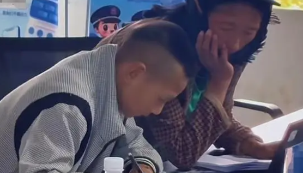 读书的意义在此刻具象化了，男孩帮身旁的大人填写资料